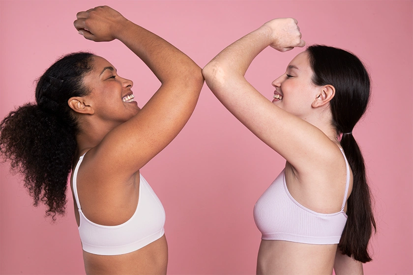 Women showing toned arms after cosmetic surgery treatment in Bangalore