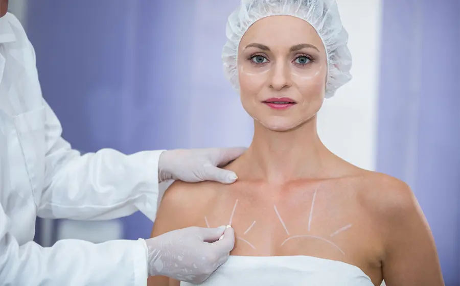 Plastic surgeon marking a female patient's chest before breast asymmetry correction in Bangalore