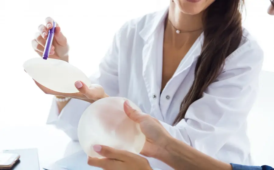 A female doctor showing breast implant options during a consultation for breast augmentation surgery in Bangalore
