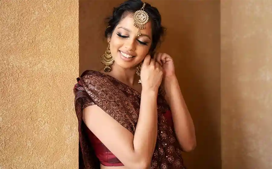 Bridesmaid smiling confidently after pre-wedding liposuction in Bangalore during outfit trials.