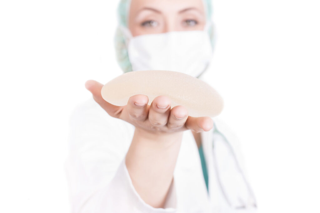 shallow focus shot female plastic surgeon holding breast implant