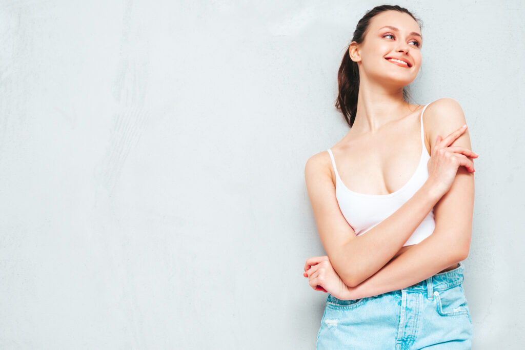 young beautiful smiling female trendy summer jeans skirt top sexy carefree woman posing near grey wall studio positive brunette model having fun going crazy cheerful happy