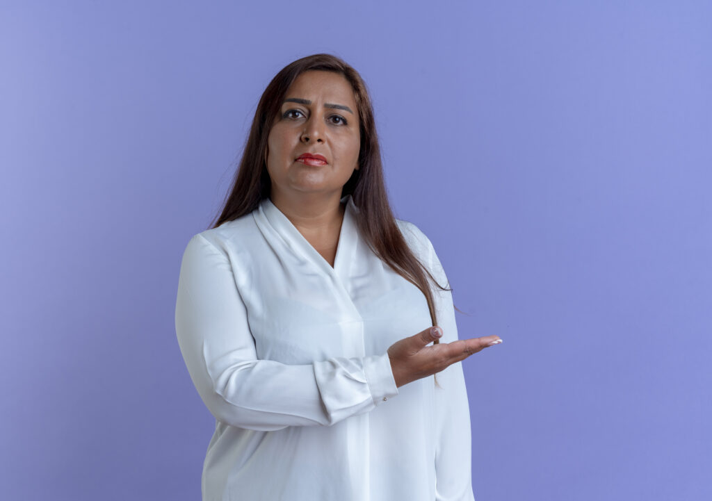 casual caucasian middle aged woman points with hand side