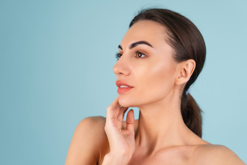 Do Cheek Implants Look Natural? What to Expect | Expert Guide to Natural-Looking Cheek Augmentation in Bangalore 1 close beauty portrait topless woman with perfect skin natural make up plump nude lips blue background