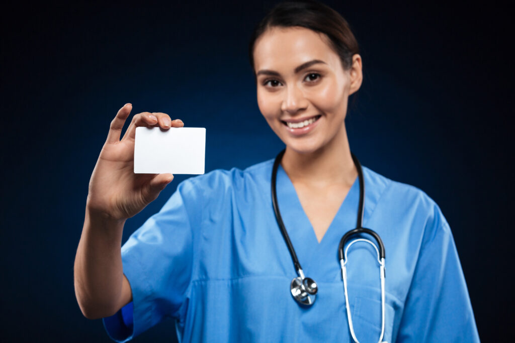 pretty doctor showing blank id card business card smiling.jpg
