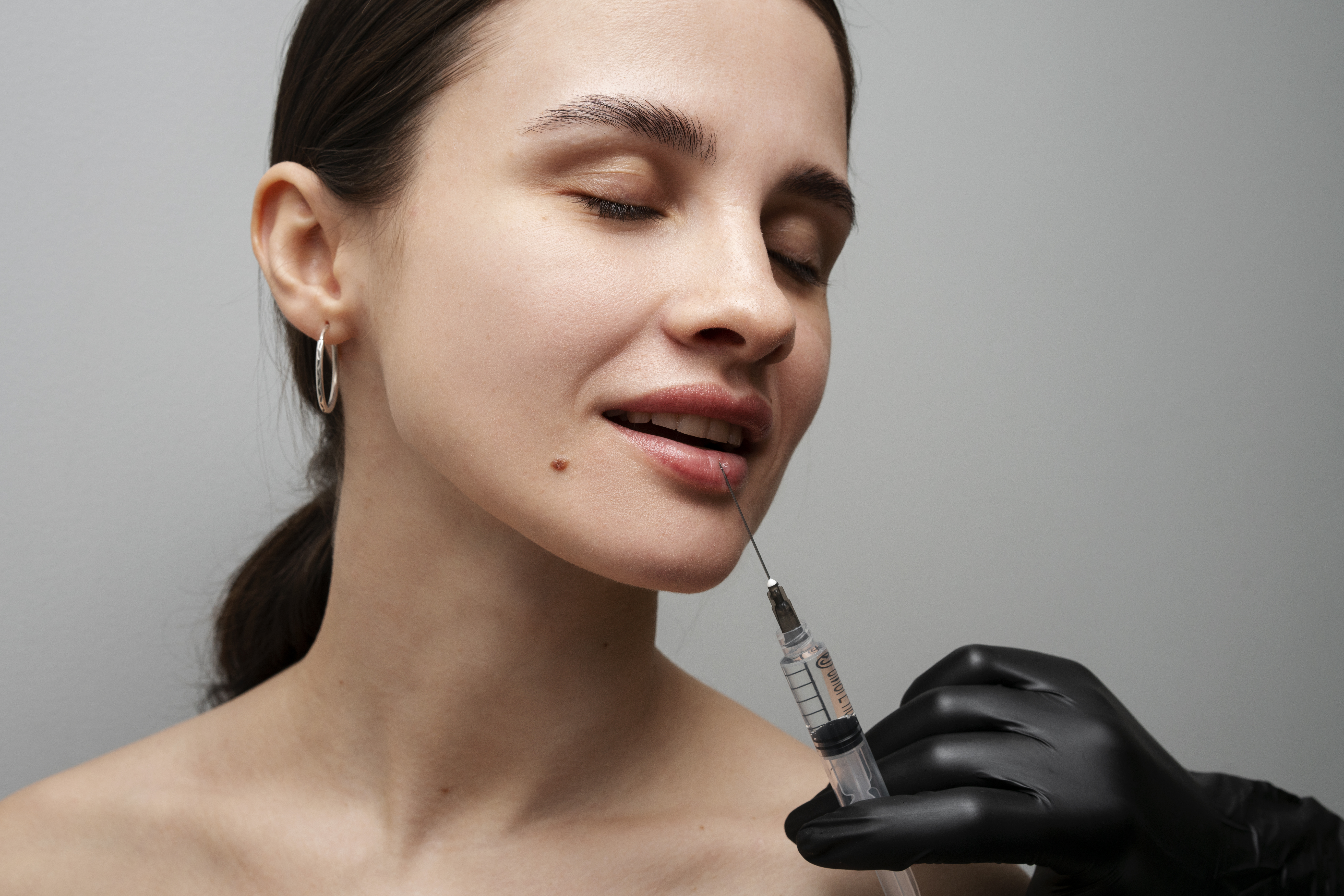 smiley woman getting lip fillers clinic