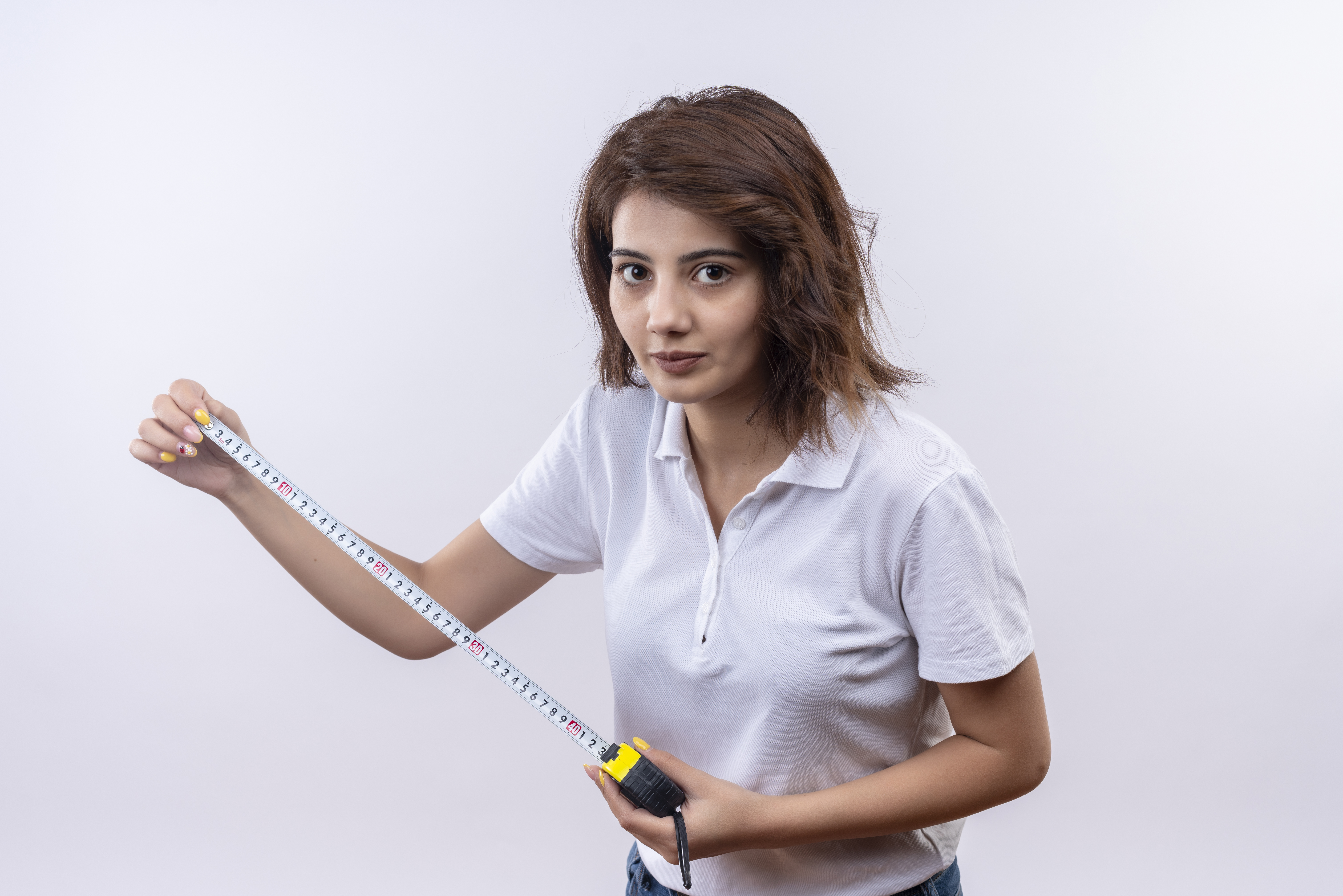 young girl with short hair wearing white polo using measure tape looking camera with confident look.jpg