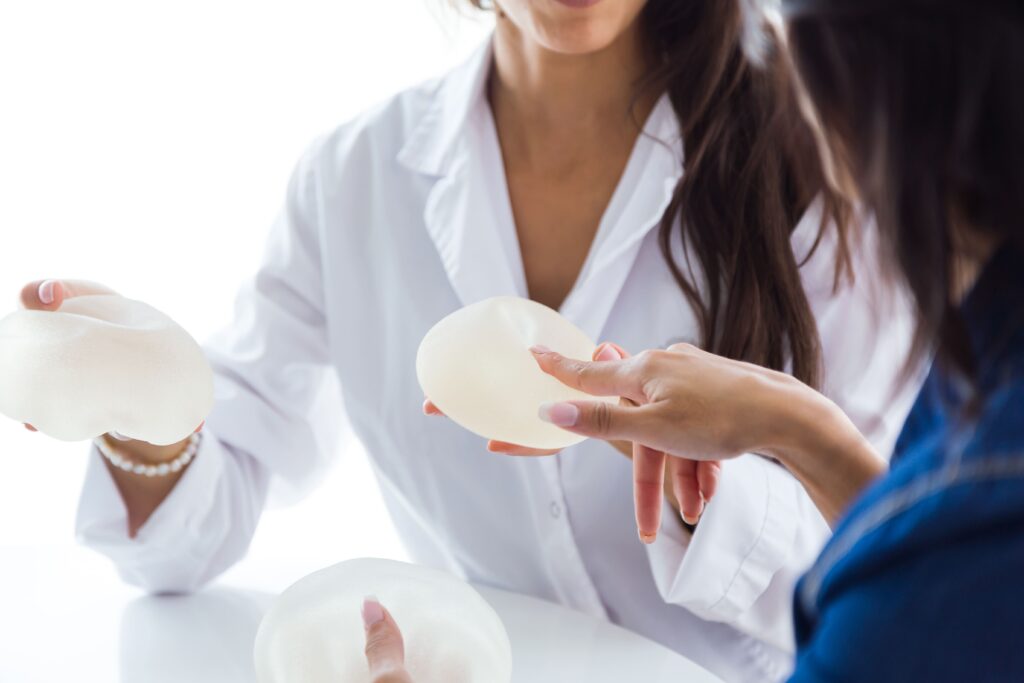 What Is the 45-55 Rule for Breast Augmentation? A Surgeon's Honest Take 2 doctor her patient choosing mammary prosthesis office.jpg